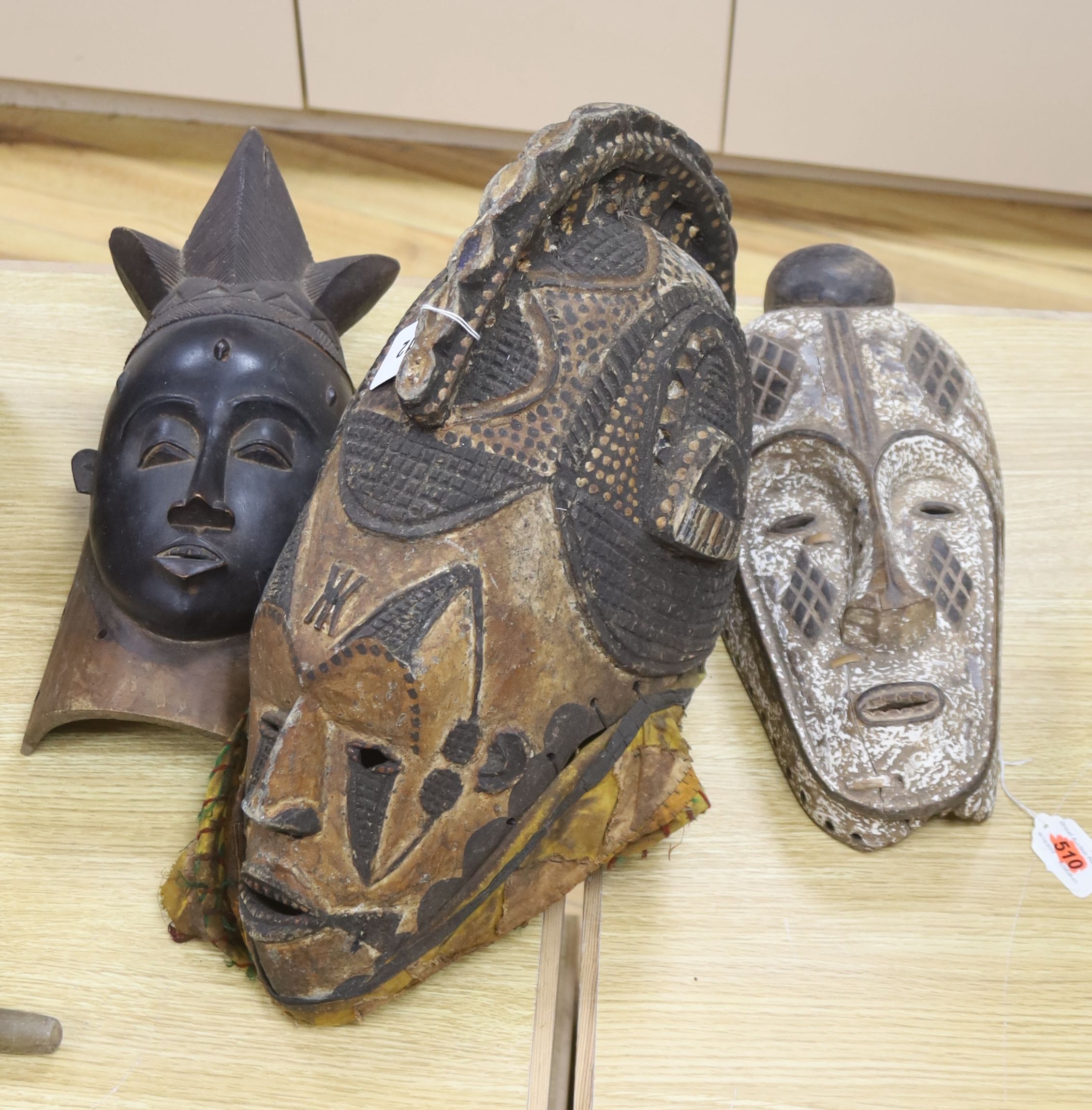 An African helmet mask, possibly Kaba, and two others